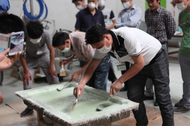 噴涂完成后，用輥筒壓實玻纖